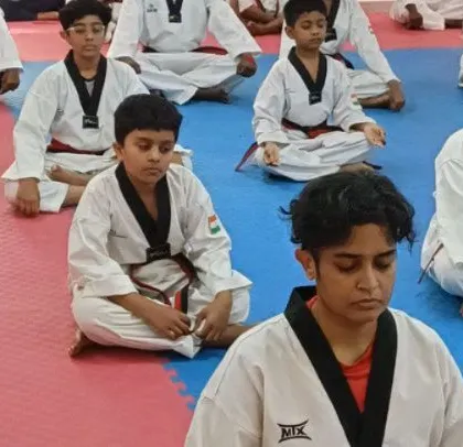 Close-up on students during meditation, a key practice for developing the focus required in martial arts.