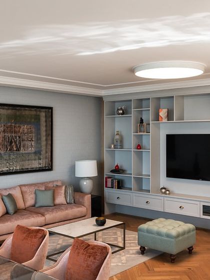 A comfortable lounge area within a director's suite at the Stainless Steel Office. The space includes a custom-built shelving unit and a soft color palette, designed to be a private retreat for the user.