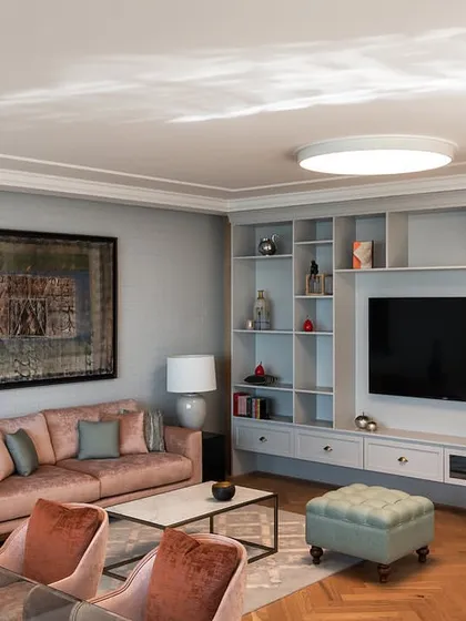 A comfortable lounge area within a director's suite at the Stainless Steel Office. The space includes a custom-built shelving unit and a soft color palette, designed to be a private retreat for the user.
