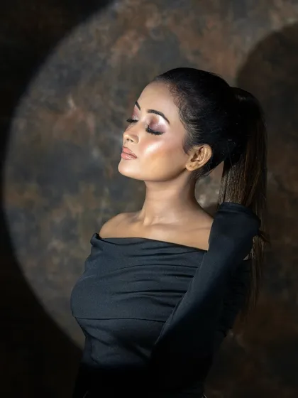 This artistic shot uses a spotlight effect to highlight the model's profile and the flawless makeup application. I teach students how to use lighting to create mood and drama in their photos.