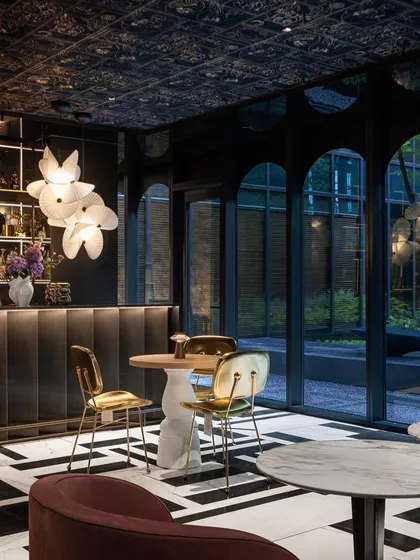 The Serpentine Light adds a touch of organic modernism to this chic bar. Its twisting form provides a soft contrast to the geometric patterns of the floor and dark tones of the room.