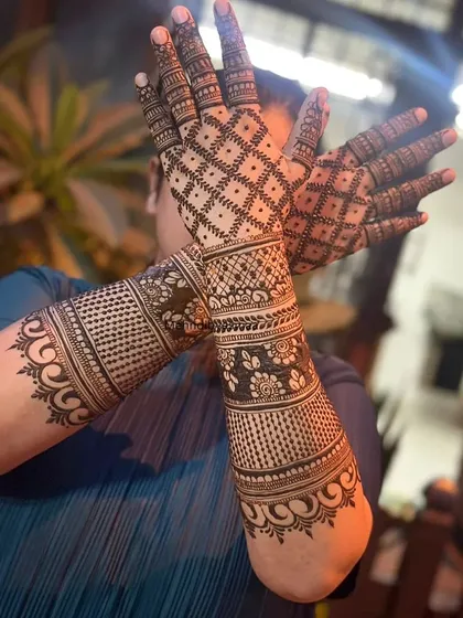 This design features heavy gridwork (jaali) on the back of the hands, complemented by floral bands on the arms for a striking effect.