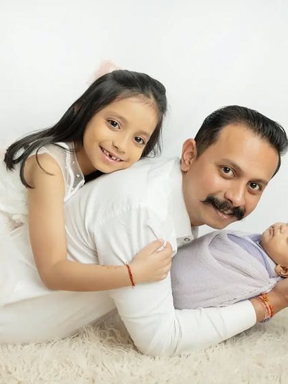 A proud father with his two angels. The older sister's happy smile says it all.