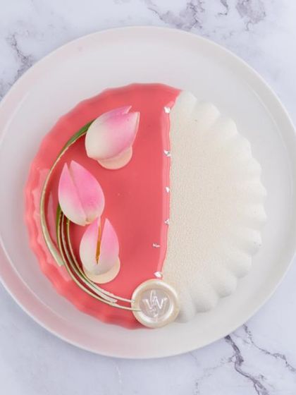 A stunning seasonal cake with a vibrant pink glaze and delicate, handcrafted tulip decorations. I use the best of the season's flavours, like strawberry and mango, to create these exotic entremets.