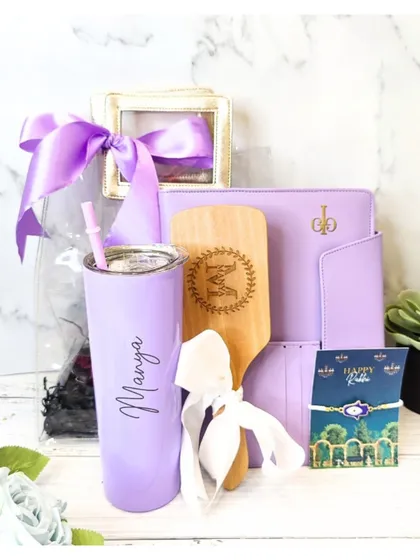This vibrant lavender Rakhi hamper includes a personalized skinny tumbler, a diary organizer, and a custom wooden hairbrush, making it a thoughtful and useful gift.
