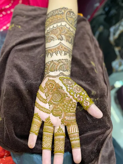The design now covers the hand, showing how the different elements connect to form a cohesive piece.