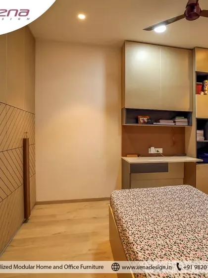 This bedroom is designed for two, with twin beds and a shared headboard wall featuring a geometric wood pattern. A long, integrated study desk with overhead cabinets provides a functional workspace for both occupants.