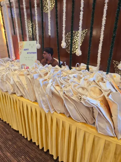 An organized and beautifully presented gift station for guests. The table is elegantly draped in yellow fabric, with a simple sign to guide attendees. It’s a small but important detail that ensures a smooth and welcoming experience.