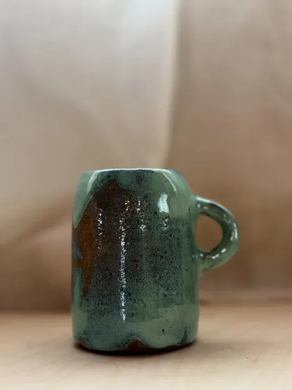 A student's creation, finished with a glossy green and earthy brown glaze. The way the colors flow together is just beautiful.