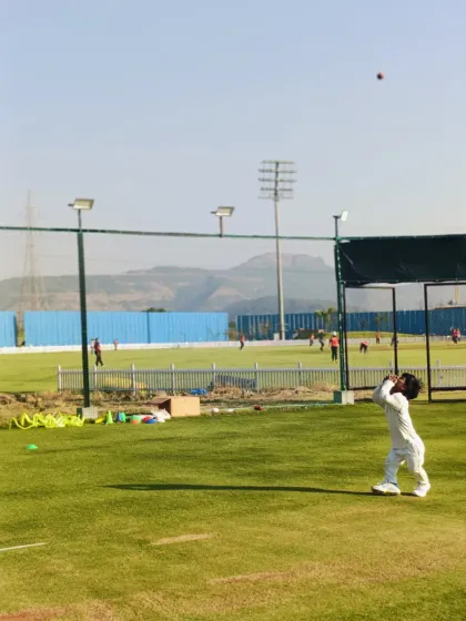 A very young player keeps his eyes on the ball, learning the basics of catching at an early age.