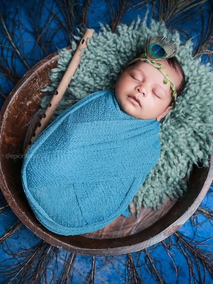 An overhead view of another Little Krishna setup, this time with a vibrant blue wrap and a full fan of peacock feathers, showcasing the versatility within our themes.