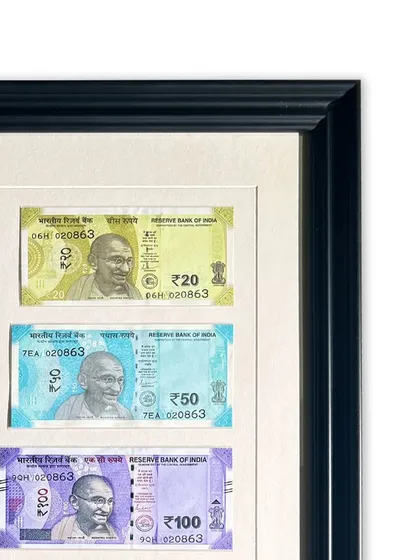 A close-up of the framed currency, showing the clean window cuts made by our computerized mat cutter. Each note is perfectly aligned and protected within the archival matting.
