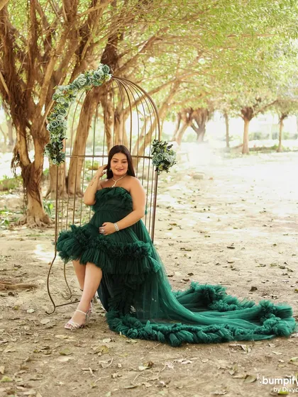 A beautiful solo portrait of the mom-to-be in the elegant birdcage chair, with her green gown flowing around her. A perfect shot for the queen of the day.