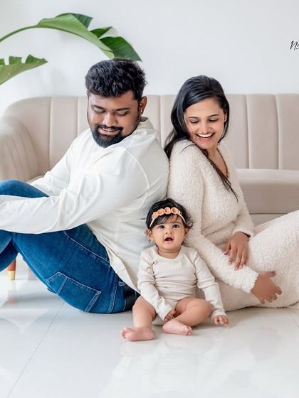 A relaxed family portrait in the studio. The neutral color palette of their outfits and the decor creates a warm, cohesive look.