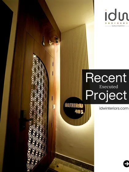 A chic and modern entrance featuring a door with an intricate geometric jaali panel. The backlit nameplate and fluted wall create a high-end, custom look.
