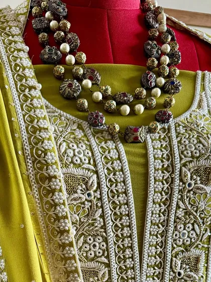 A close-up of the neckline, styled with a traditional necklace to highlight its festive appeal.