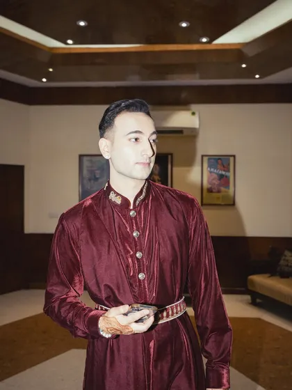 A full-length view of the maroon outfit, showing the custom belt and the flow of the fabric.