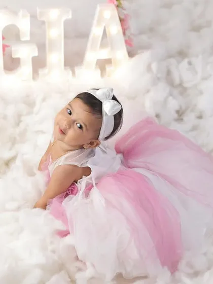 An adorable shot of baby Gia looking up, surrounded by soft white clouds and her glowing name.