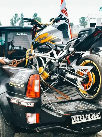 A stunt bike is carefully unloaded from a truck. The logistics and preparation behind the scenes are immense, ensuring every part of the show runs smoothly and safely.