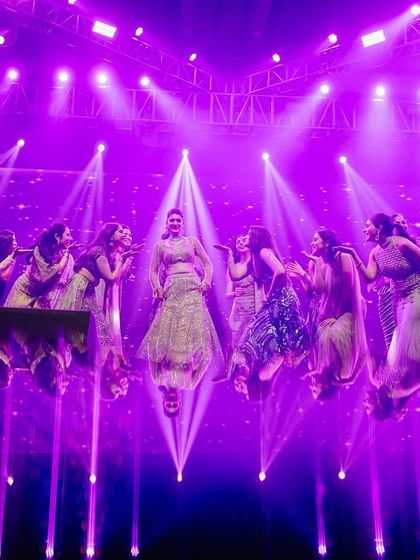 A stunning shot of the bride and her squad, captured from above. The reflection on the glossy floor and the dramatic purple lighting created a unique, visually striking image.