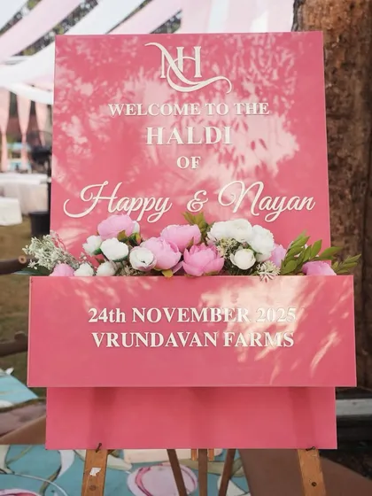 Personalization is key. This custom welcome sign for Happy and Nayan's Haldi ceremony uses a beautiful font and a floral accent box, perfectly matching the event's pink-themed decor.