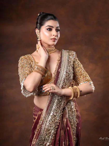 A side profile that highlights the elegant drape of the saree and the beautiful hair accessory. This is a sophisticated shot for any ethnic wear collection.