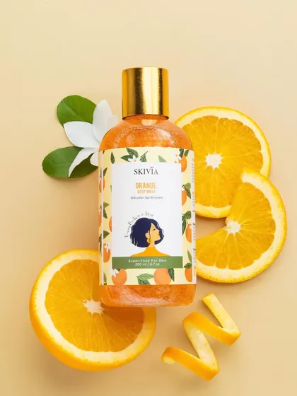 A classic top-down flatlay for an orange-scented body wash. The product is surrounded by fresh orange slices and peels, creating a vibrant and zesty composition that smells as good as it looks.