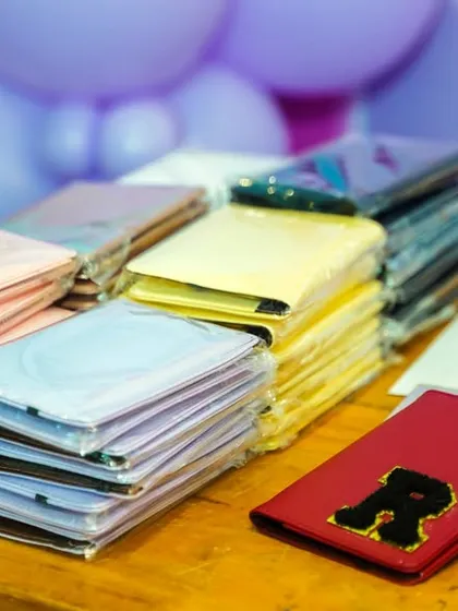 A table full of passport holders ready to be personalized as a unique party favor.