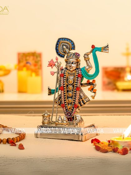 This intricately detailed silver-plated Shrinathji idol is a masterpiece of devotional art. The colorful embellishments and fine craftsmanship make it a stunning addition to any spiritual collection or home decor.