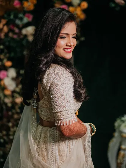 A side view of Sejal's reception look, showing off her voluminous waves and the intricate details of her lehenga blouse.