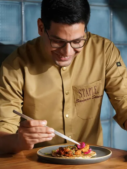 The chef adding the final, delicate touches to a dish. This image highlights the artistry and attention to detail that defines the restaurant's culinary approach.