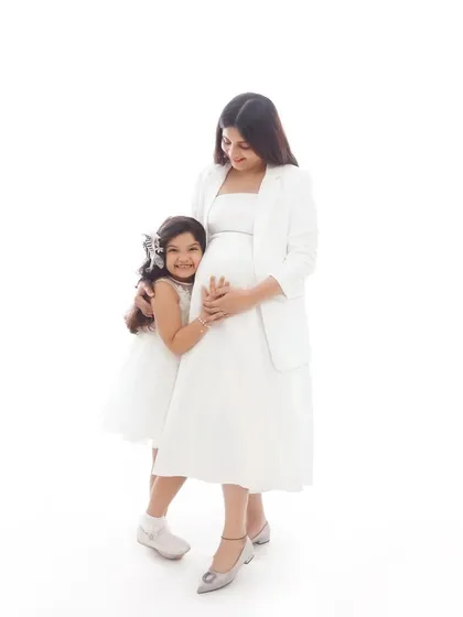 A sweet moment between a mother and her daughter during a maternity session. The daughter's hug around the baby bump is a beautiful symbol of her love for her coming sibling.