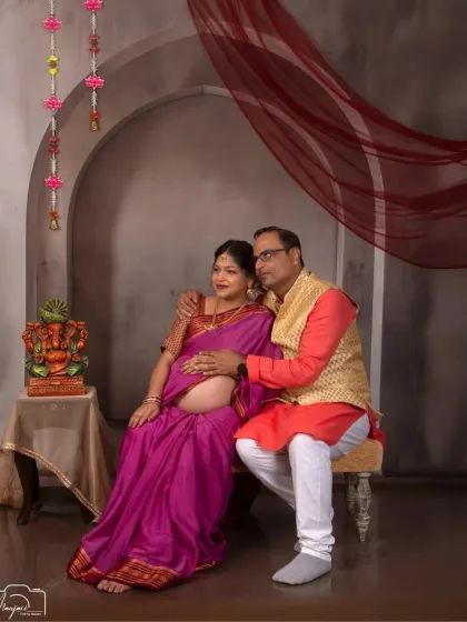 A sweet couple's portrait in a traditional setting. The way he holds her bump shows his excitement and love.