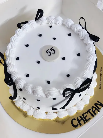 A closer look at the vintage black and white cake, showing the neat piping and bow details.