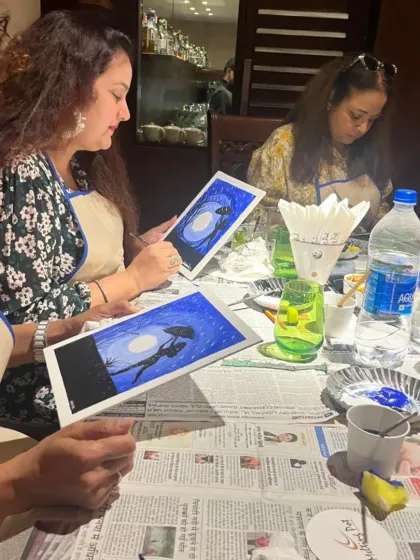 Friends gathered around the table, engrossed in their monsoon-themed paintings. I provide all the materials, from aprons to paints, so you can just relax and create.