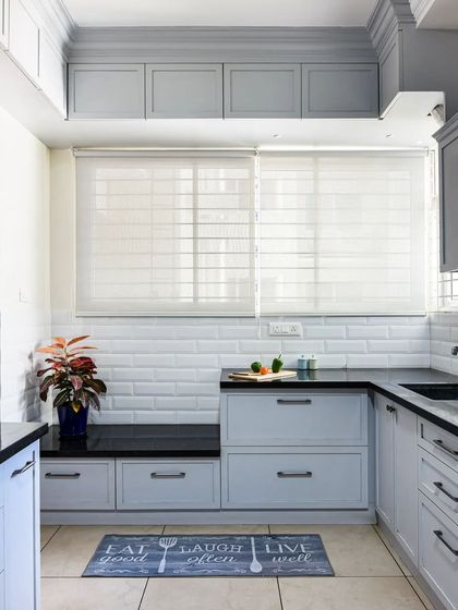 Another angle of the kitchen nook, demonstrating how even a small kitchen can incorporate a comfortable seating area. The soft grey cabinets and white subway tiles create a calm and inviting atmosphere.