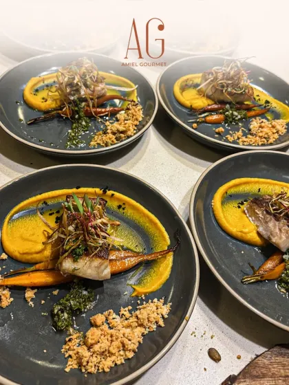 Every plate tells a story. Here, beautifully seared fish is plated with a vibrant carrot puree and roasted baby carrots, showcasing the visual artistry we bring to every private catering event.