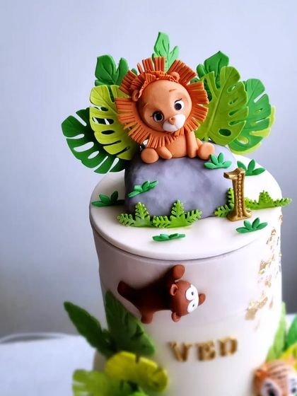 A close-up of the lion topper on the rotating safari cake.