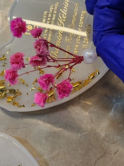 Adding the final touches to a heart-shaped magnet. The pink flowers look so delicate.