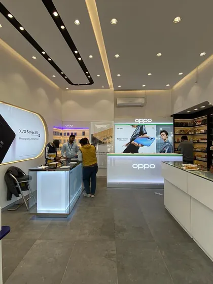 A look inside the completed Mobile Plaza in Rewari. The design uses clean white counters with integrated lighting and a streamlined layout to create a modern, high-tech environment for a gadget showroom.