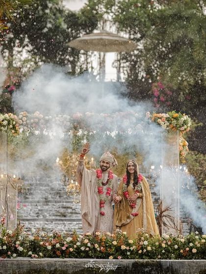 A dramatic shot with smoke bombs going off as the couple stands together at their mandap.