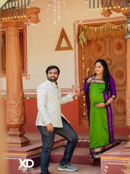 A candid shot of a couple interacting on the steps of a traditional house, capturing a moment of genuine connection.