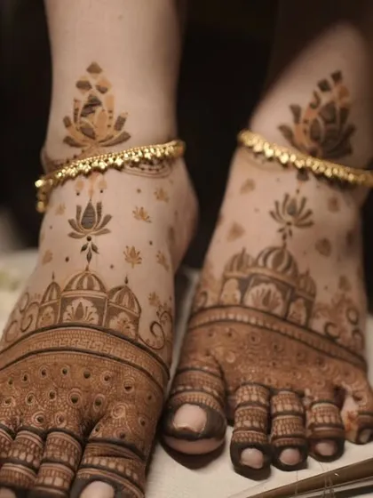 Bridal mehendi isn't complete without adorning the feet. This design features delicate lotus flowers and architectural domes, creating an elegant look that complements the anklets perfectly.