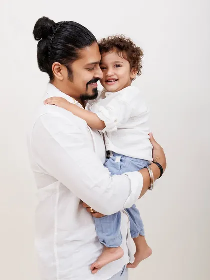 The bond between a father and his child is powerful. This portrait highlights that special connection in a simple, classic studio setting.