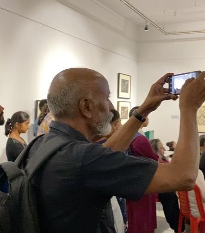 A visitor capturing the moment on his phone during the talk.