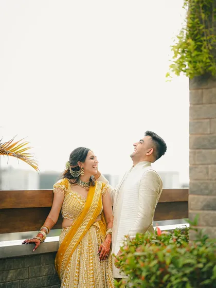 Capturing pure, unscripted laughter. This candid moment on a balcony shows the couple sharing a genuine laugh, a memory they will surely treasure.