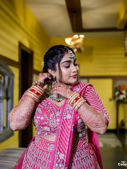 A beautiful shot of the bride getting ready, adjusting her earrings. These quiet, behind-the-scenes moments are an important part of the wedding story.