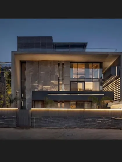 The facade of the 'Green Court Villa' at night. The combination of raw stone, large glass panels, and warm illumination creates a welcoming and sophisticated presence on the street.