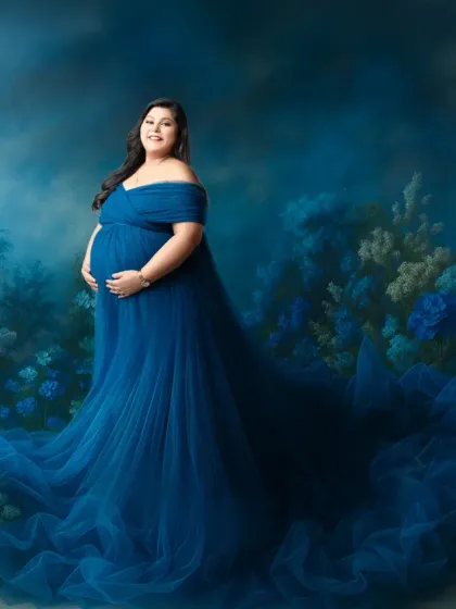 Lost in a fairytale dream. This enchanting portrait places the mother-to-be in a magical, painted landscape of blue flowers. Her flowing blue tulle gown blends seamlessly with the scenery, creating an image straight out of a storybook.