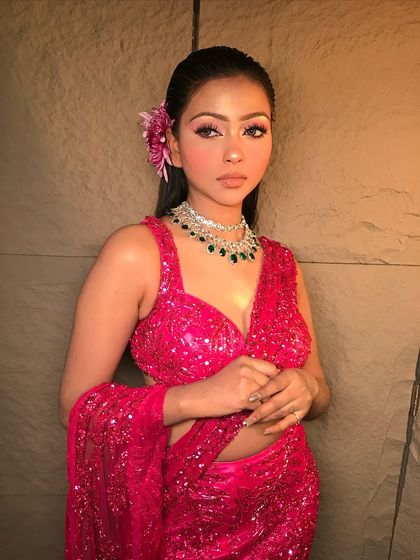 A full view of the sparkling pink saree, perfect for a cocktail or sangeet event. The makeup is kept fresh and light to complement the outfit.